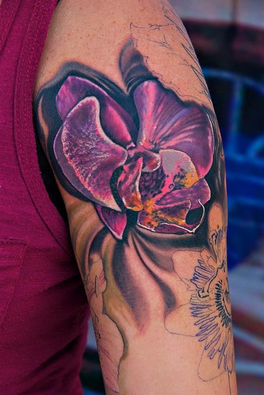 Cool bright violet tropical flower tattoo on upper arm