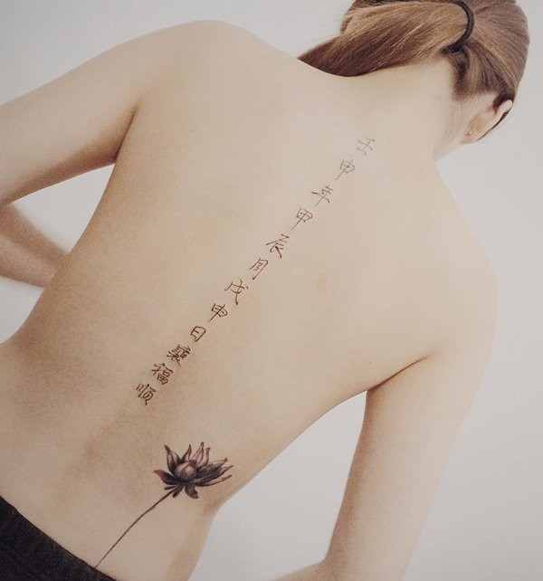 3D like beautiful black ink Asian lettering tattoo on back with flower