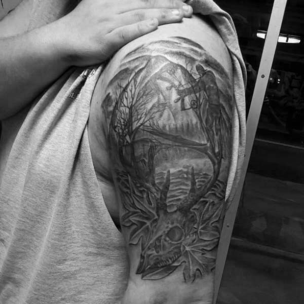 Tatuaje en el brazo, cazador en el bosque y cráneo de un animal con cuernos