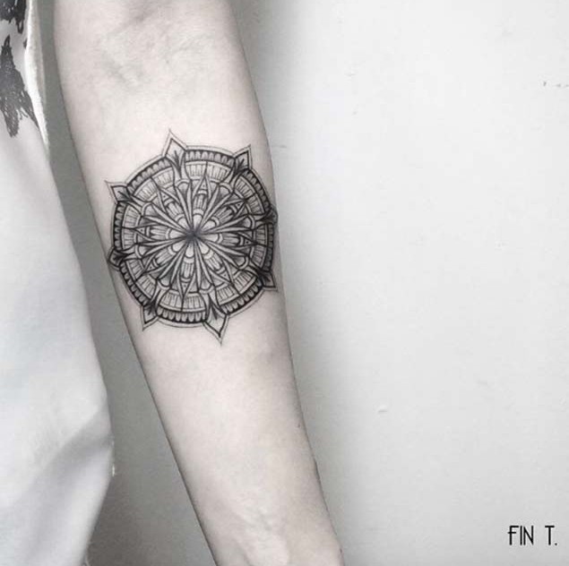 3D like big black ink flower shaped tattoo on forearm