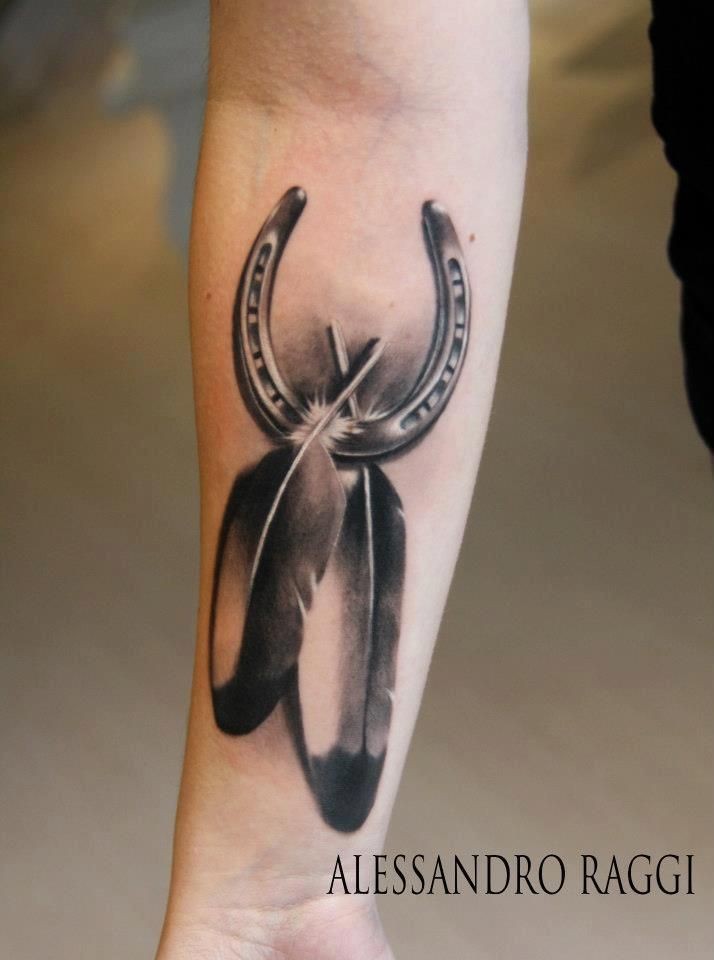 3D like big detailed lucky horseshoe with feather tattoo on arm