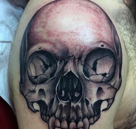 3D like black and white corrupted skull tattoo on arm top