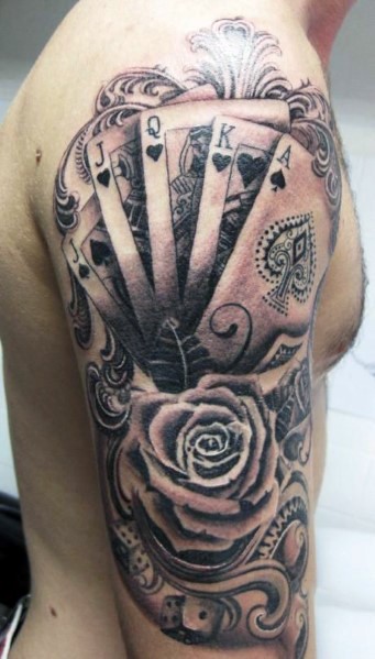 Tatuaje en el brazo,
naipes con rosa, ornamento y dados