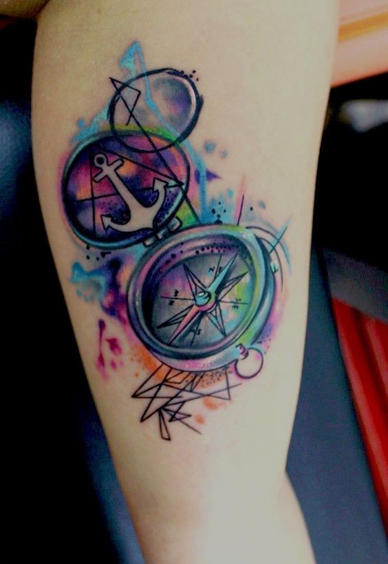 Tatuaje en el brazo, compás multicolor con emblema ancla