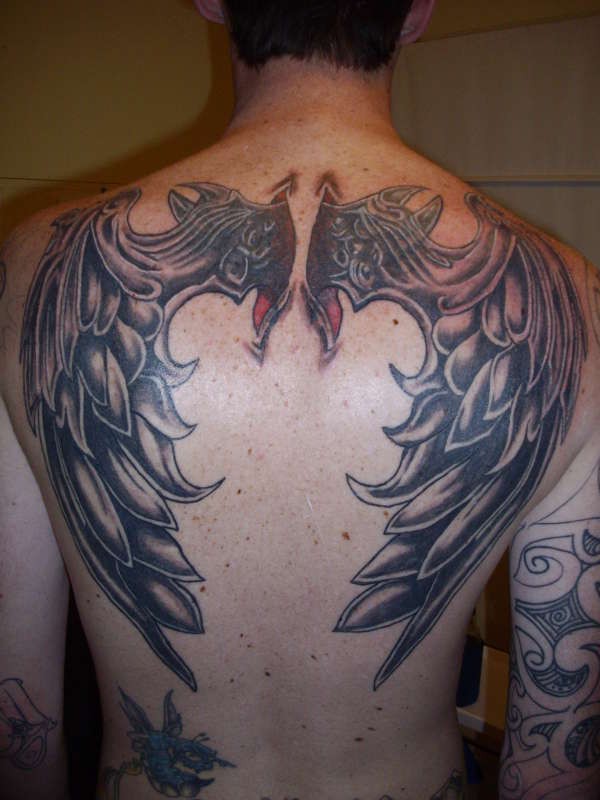 3D like interesting painted and detailed colored big wings tattoo on upper back