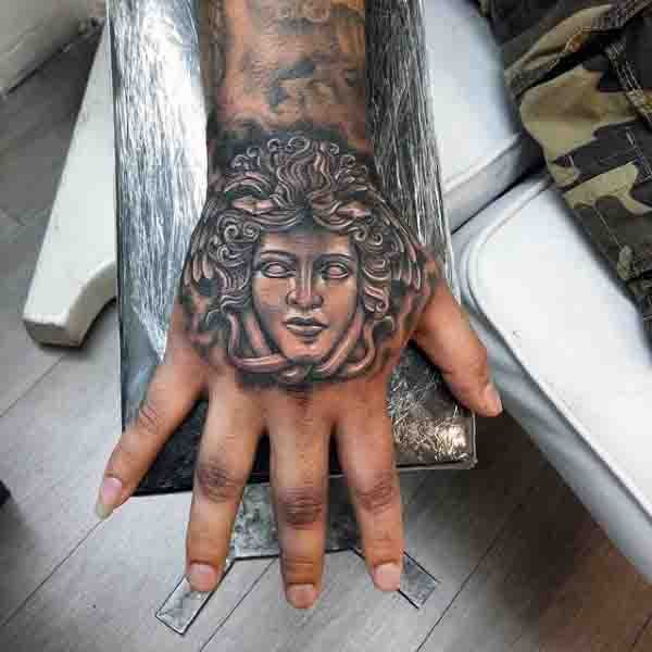 Tatuaje en la mano, cara de medusa gorgona simple