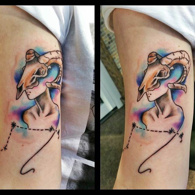 3D like multicolored alien with goat skull tattoo on arm