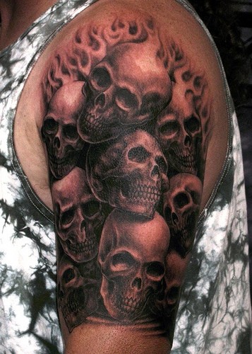 Tatuaje en el brazo, un montón de cráneos en el fuego, colores negro y blanco
