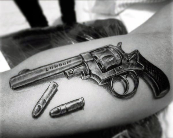 3D like very realistic old revolver with bullets tattoo on arm