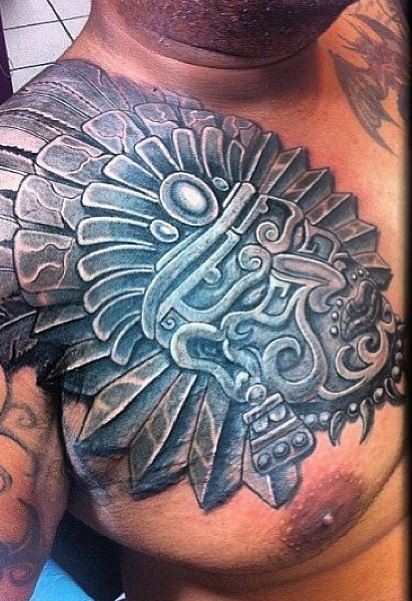 Tatuaje en el pecho, máscara de piedra de deidad azteca