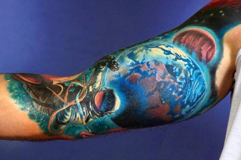 Tatuaje en el brazo, planetas increíbles con astronauta pequeño