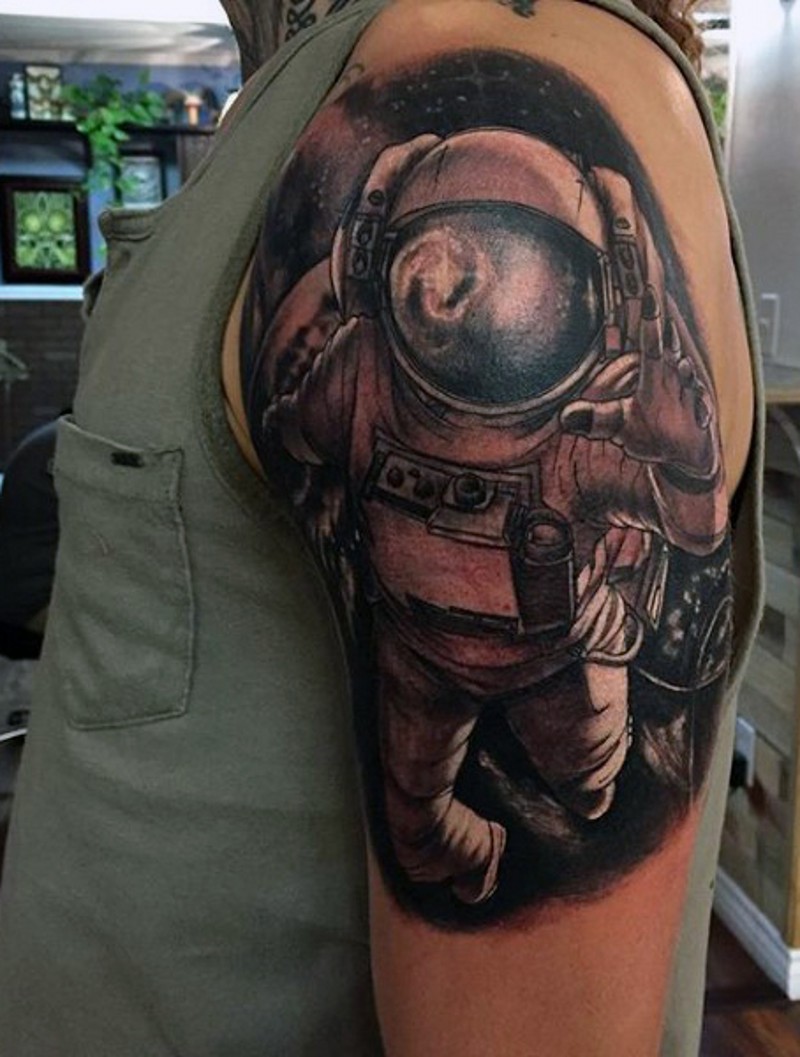 Tatuaje en el brazo, astronauta grande en gravedad cero