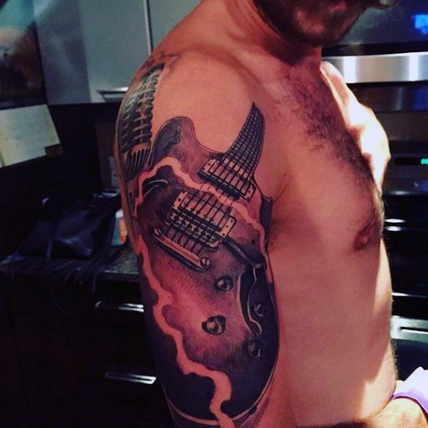 Tatuaje en el brazo, guitarra eléctrica con 
micrófono preciosos
