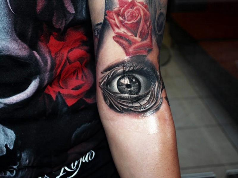 3D style black and white arm tattoo of human eye and red rose