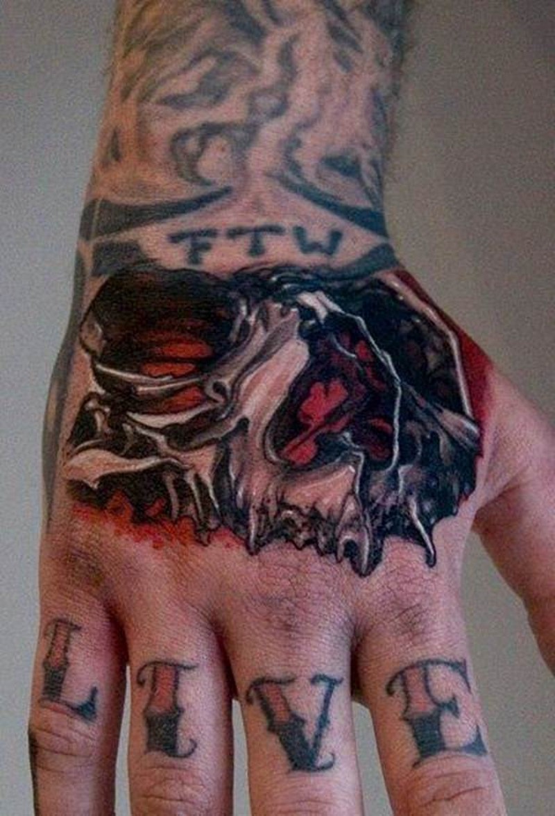3D style colored little skull part tattoo on hand combined with lettering