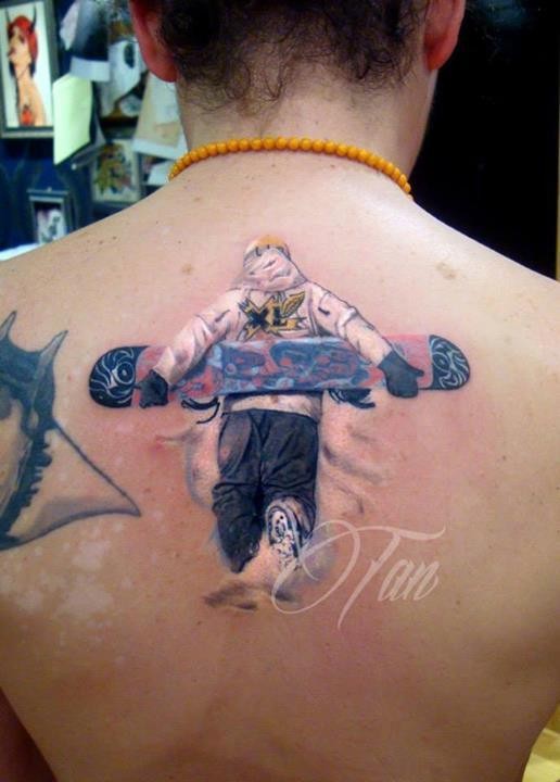 3D style colored upper back tattoo of man with large snowboard