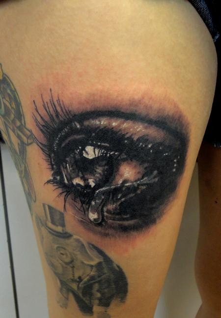 3D style detailed thigh tattoo of crying human eye