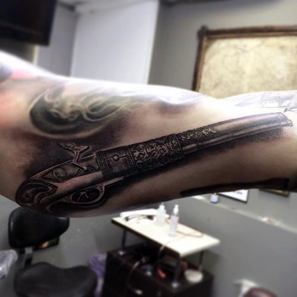 3D style very detailed arm tattoo of antic pistol