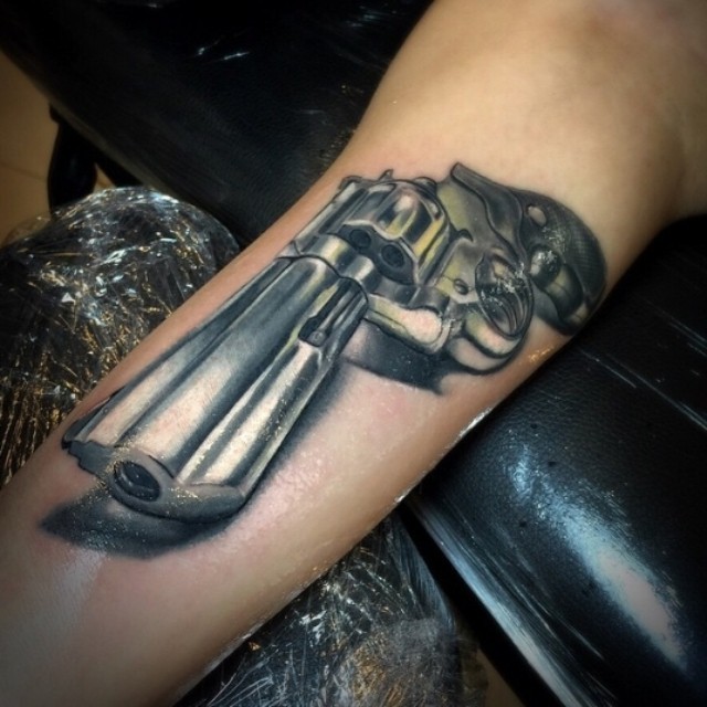 Tatuaje en el brazo,
pistola preciosa muy realista