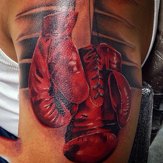Tatuaje en el brazo, guantes de boxeo rojos realistas