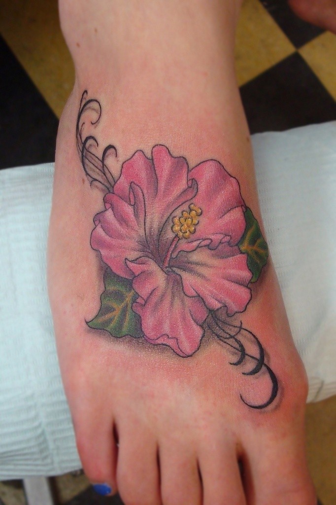 Amazing pink-colored hawaiian flower tattoo on foot