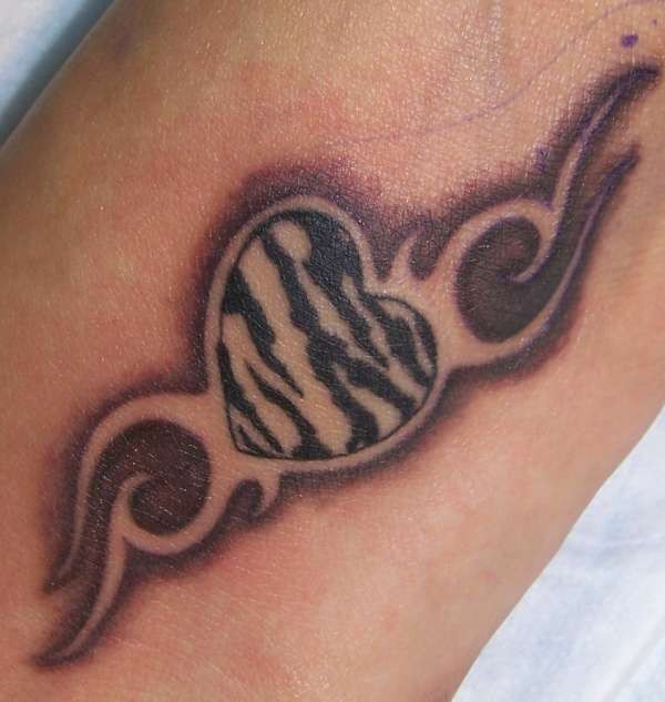 Amazing zebra striped heart tattoo on arm