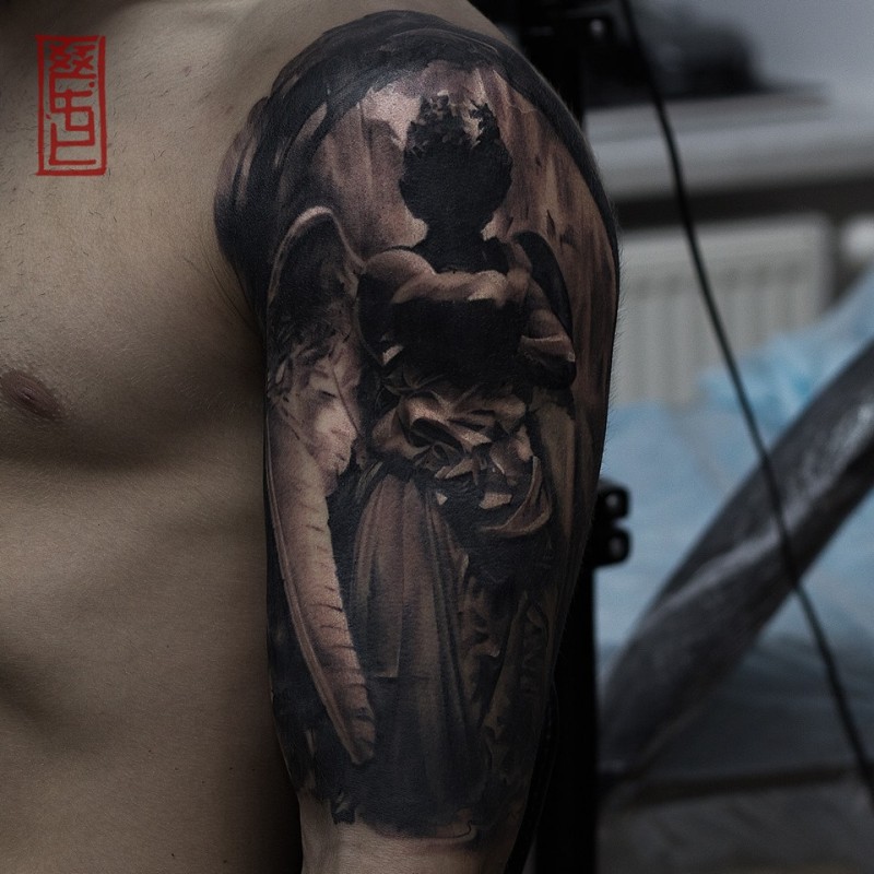 Angel statue tattoo on shoulder