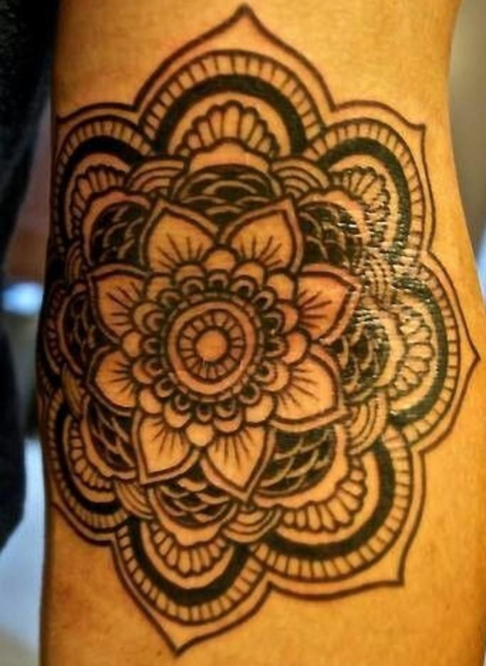 Awesome black-ink mandala flower tattoo on arm