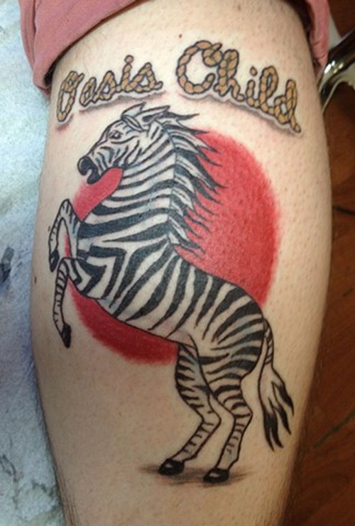 Awesome color-ink zebra with red sun and quote tattoo on shin