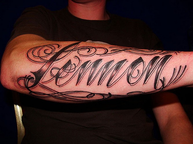 Tatuaje en el antebrazo, nombre, letra negra estilizada
