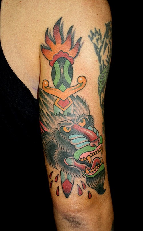 Erschütterndes Oberarm Tattoo im altschulischen Stil von durchgeschlagenem mit Dolch Paviankopf
