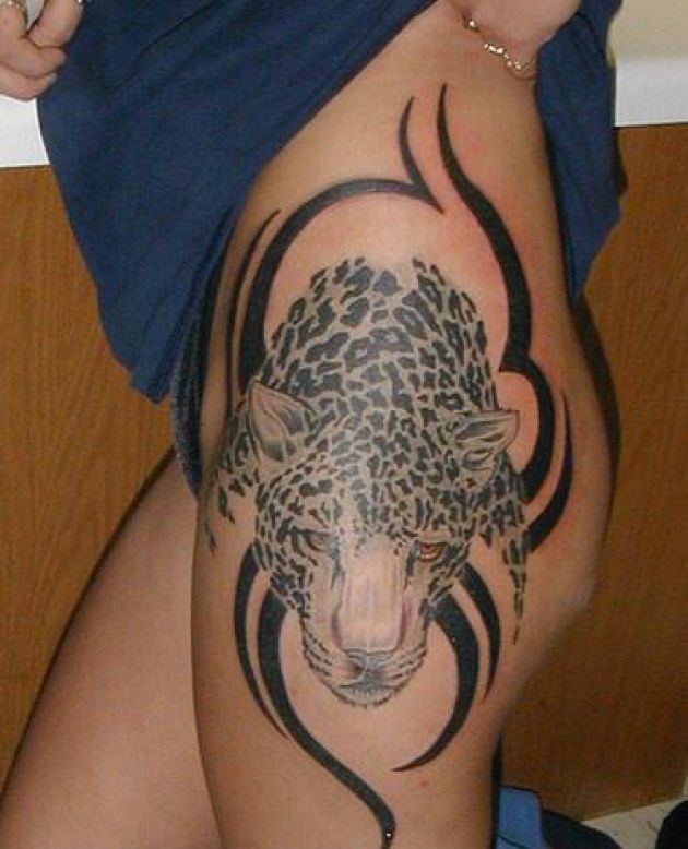Tattoo mit schönem Gepardenkopf mit Stammesornament im Hintergrund an der Hüfte