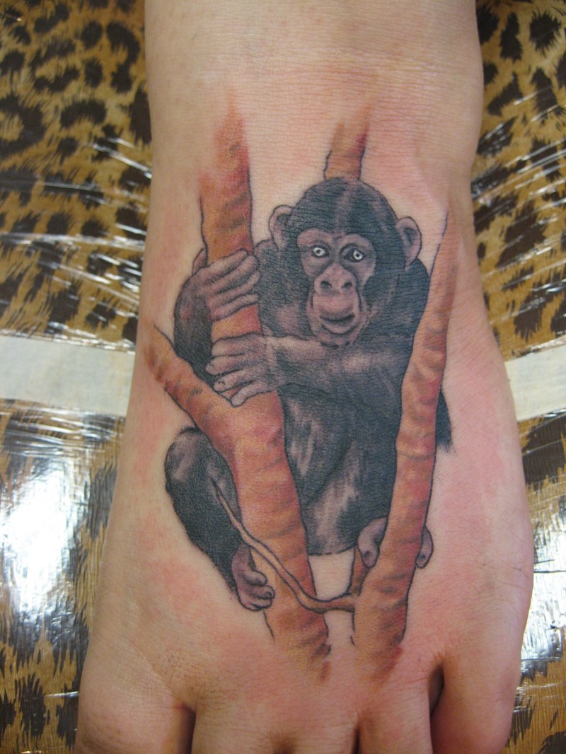 Tatuaje en el pie, chimpancé negro en el árbol
