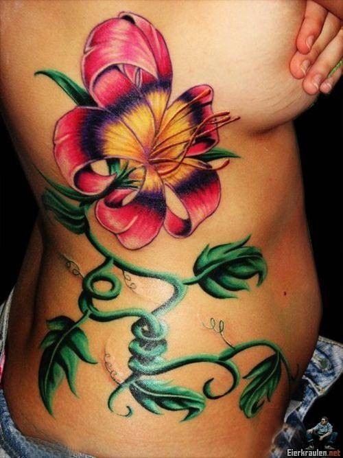 Beautiful colorful exotic flower tattoo on side