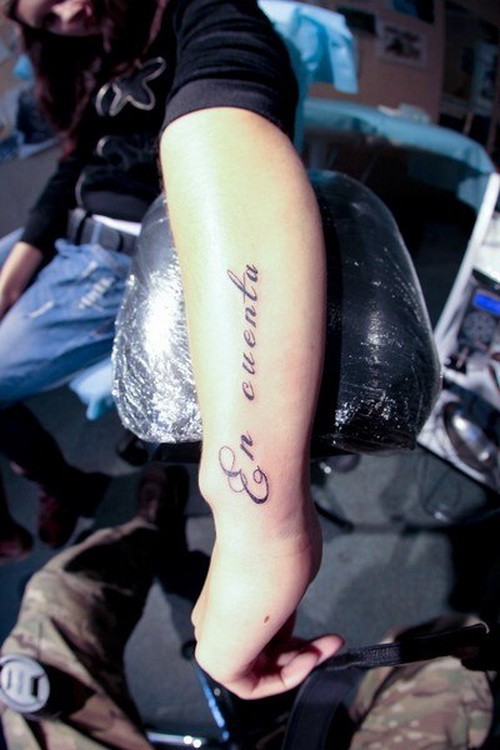 bellissima scrittura en cuenta con riccioli tatuaggio su braccio