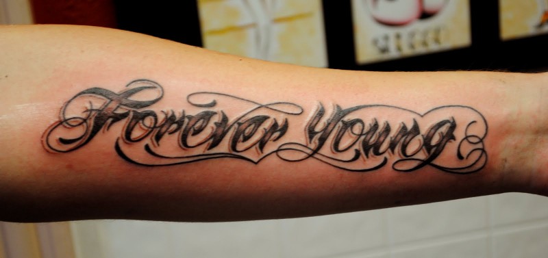 Beautiful forever young graffiti quote tattoo on arm