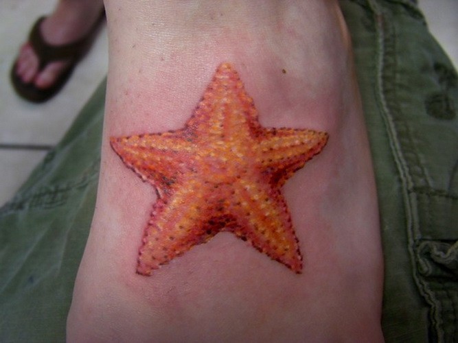 Tattoo mit großem orange Seestern am Fuß
