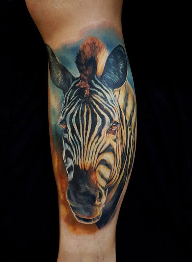 Beautiful realistic color-ink zebra head tattoo on leg