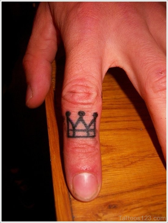 Schöne kleine schwarze  Krone Tattoo am Finger