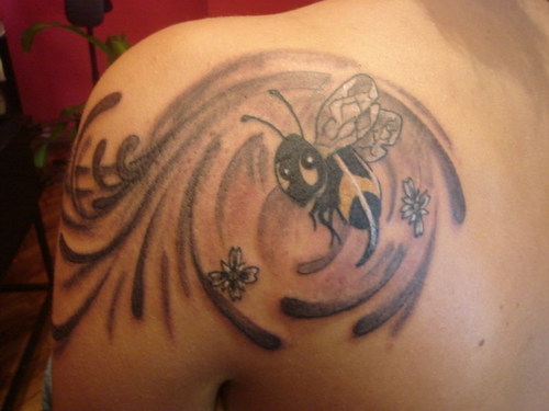 Tatuaje en el hombro, abeja en el vórtice