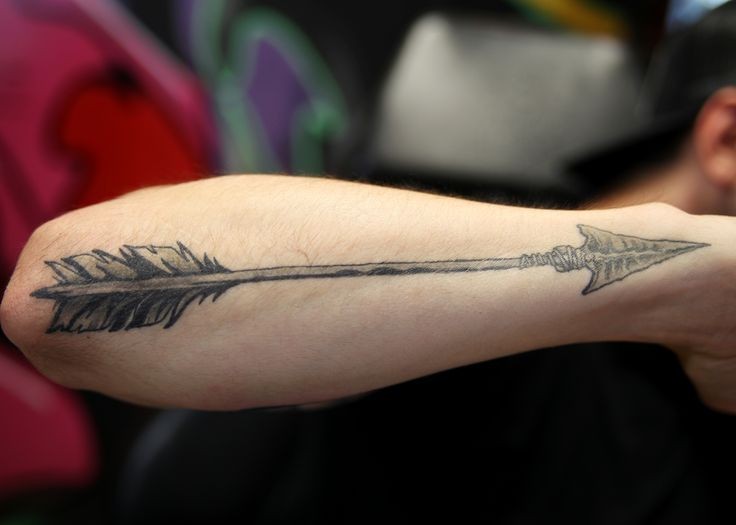 Tatuaje en el antebrazo, flecha vieja desgastada