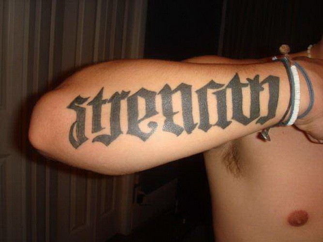 Tatuaje en el antebrazo, palabra con letra gruesa negra