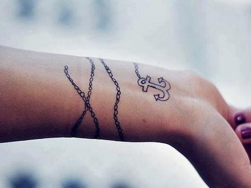 Black-and-white anchor infinity tattoo on chain tattoo on wrist
