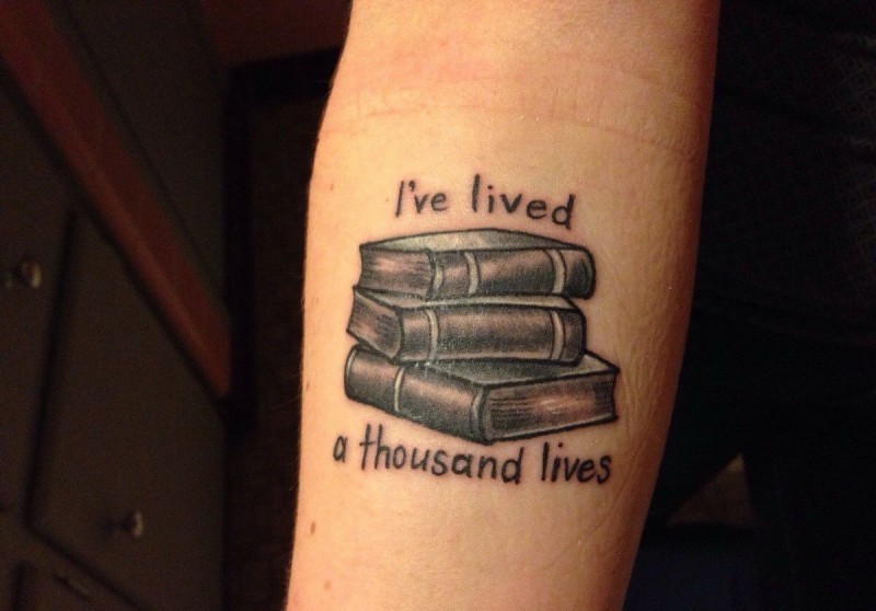 Black-and-white books with quote tattoo on forearm