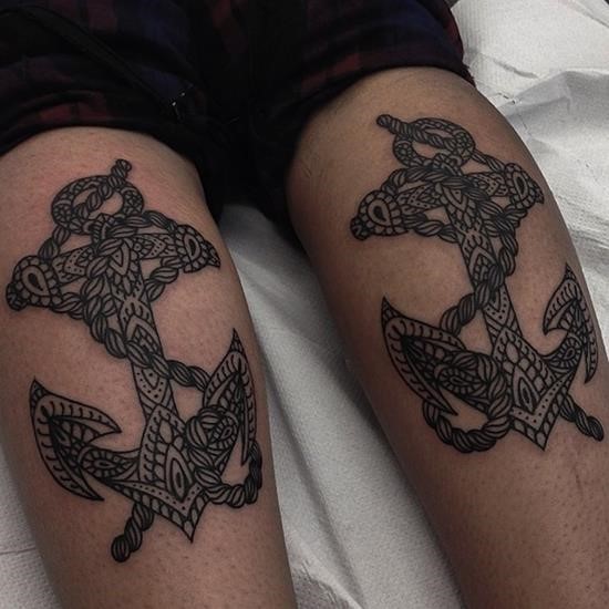 Black-and-white double anchors with ornaments tattoo on thighs