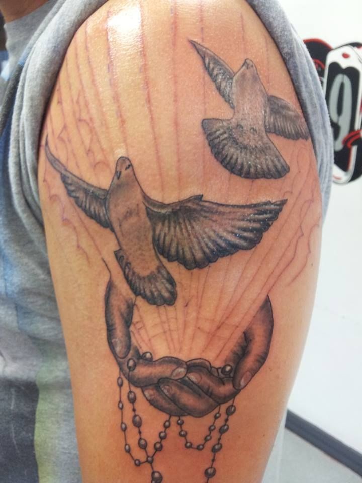 Black-and-white doves  with hands and beading tattoo on upper arm