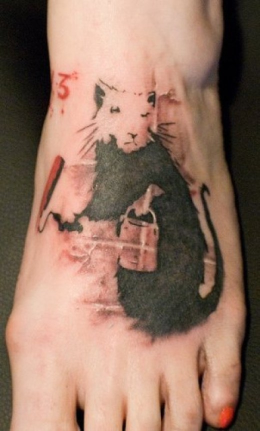Black-and-white rodent with bucket tattoo on foot
