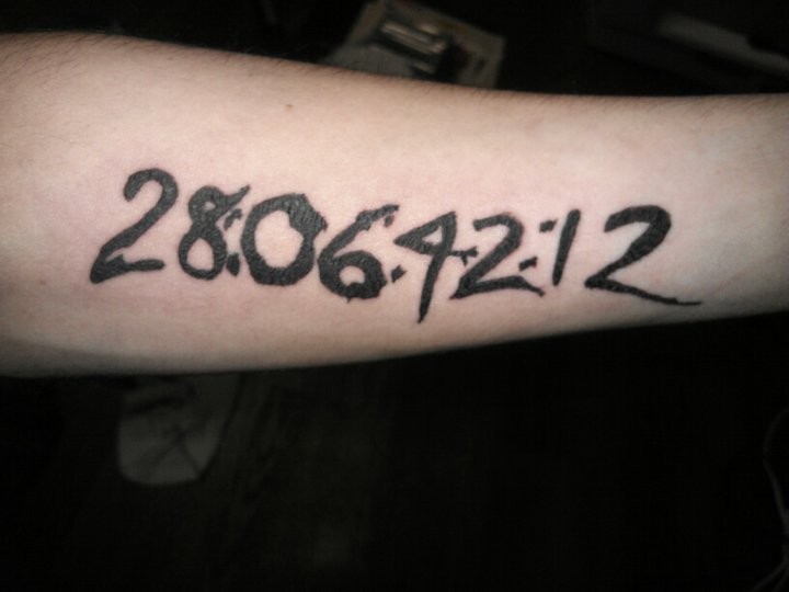 Black-and-white thick numbers quote tattoo on arm