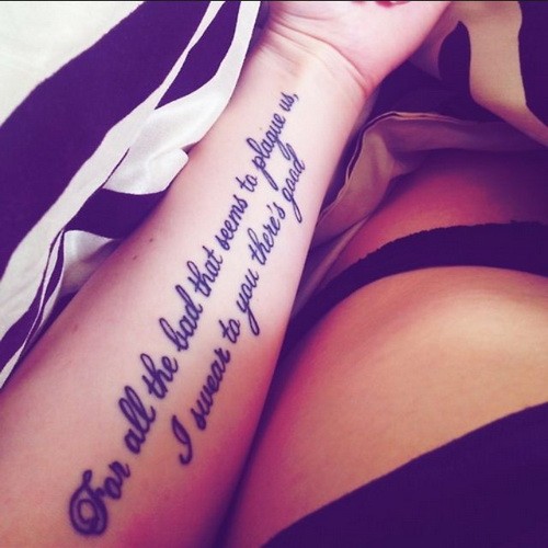 Black-and-white two-lined quote tattoo on arm