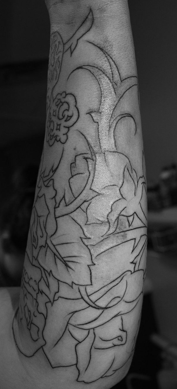 Black-contour flower tattoo sleeve on forearm